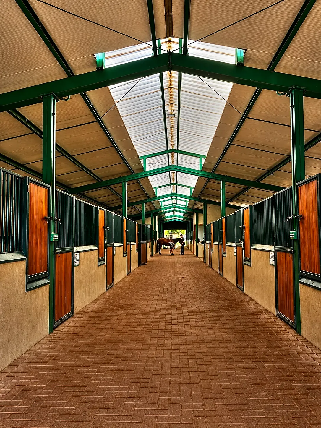Corredor de baias de haras com portas de madeira